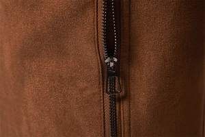 Detailed macro view of the premium brown suede fabric texture and smooth metal zipper