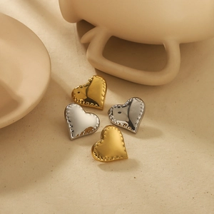 Boucles d'oreilles cœur texturées minimalistes en finition or 18k et argent sur tissu