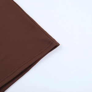 Gros plan sur l'ourlet à double couture du tissu en maille marron de la robe sexy