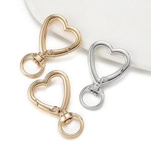 Detail of heart-shaped lobster clasps in gold and silver finish for DIY jewelry