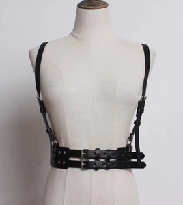 Detail of black leather body harness with dual silver buckles and adjustable straps
