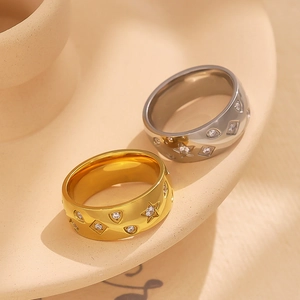 18k gold and silver stainless steel rings with star-shaped zircon inlays on ceramic tray