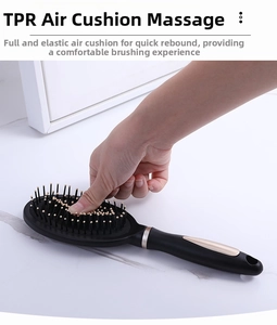 Detail of hand pressing the flexible TPR air cushion massage hairbrush for scalp relief