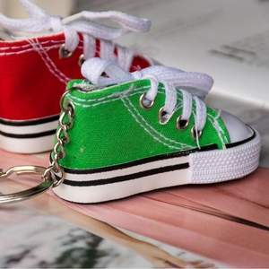 Mini canvas sneaker keychain with white laces and rubber sole in red and green colors