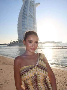 One-shoulder lace dress with colorful wave patterns at the beach with Burj Al Arab view