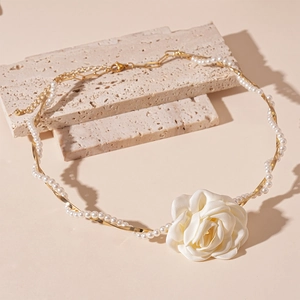 Detail of fabric flower pendant with faux pearl beads and golden chain choker