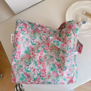 Set of floral cotton tote bags with pink flower patterns and brand label on white desk