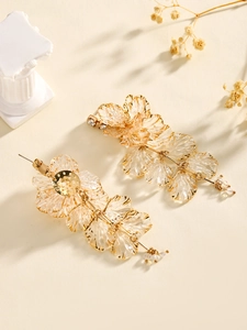 Exquisite gold floral drop earrings with champagne resin petals on elegant neutral background