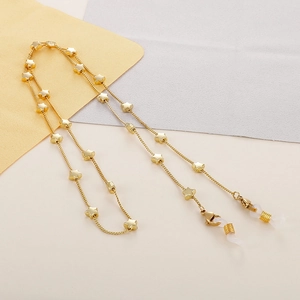 Detail of golden star-shaped eyewear chain with metal lobster clasp and silicone loop