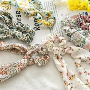 Floral chiffon hair scrunchie details with elegant long ribbons on a minimalist background