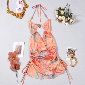 Détail d'une robe licou orange tie-dye avec découpe frontale et cordons de serrage latéraux