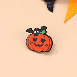 Detail shot of Halloween enamel pin with orange pumpkin and cute black bat design