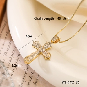 Detail of 18K gold cross necklace with crystal heart and specific size dimensions