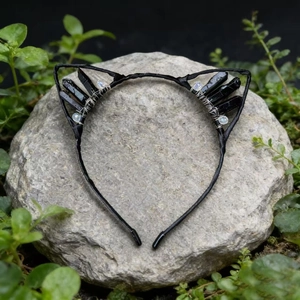 Detail view of handmade cat ear headband with black crystals on a natural stone base