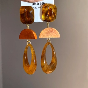 Detail of retro amber resin and wood grain hoop earrings with gold metal links