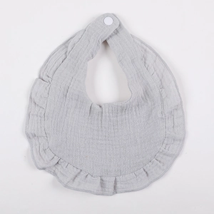 Detail of grey muslin cotton baby bib with ruffled petal edges and white snap fastener
