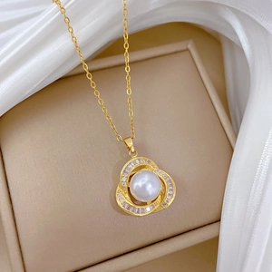 Detailed close-up of a golden flower pendant featuring a central pearl and small diamonds
