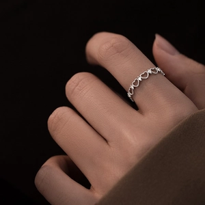 Detailed close-up of a silver heart chain ring with cubic zirconia stones on a model hand