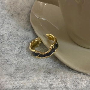 Detail shot of vintage gold-plated enamel ring on ceramic edge with soft knit background