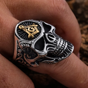 Macro shot of silver skull ring featuring a golden freemasonry symbol detail