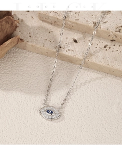 Macro detail of silver Evil Eye pendant with blue core and pavé zircon stones