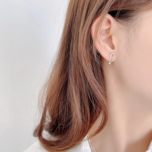 Minimalist 925 sterling silver musical note asymmetric earrings shown on a model