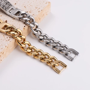 Luxury gold and silver chunky Cuban link bracelets displayed on marble stone
