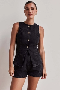 Dettaglio del set denim nero con gilet e pantaloncini che mostra bottoni metallici