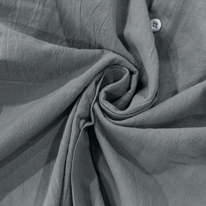 Vue macro détaillée de la texture gris lin coton et du bouton sur la chemise homme