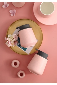 Detail of pink matte ceramic soap dispensers with black speckled texture and gray pumps