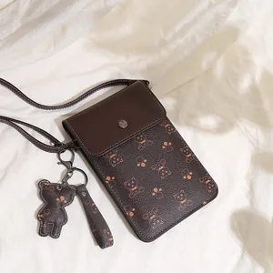 Detail of dark brown PU leather mini bag featuring bear patterns and metal snap button