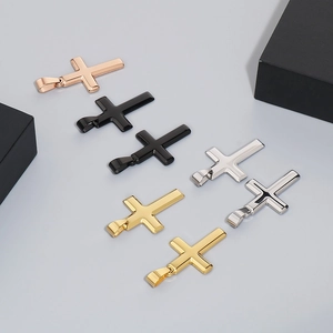 Flat lay view of cross pendants in rose gold, black, silver, and gold stainless steel
