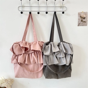 Detail of pink and grey canvas tote bags with elegant double-layered ruffle trims