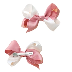 Pink and white fabric ribbon bow hair clips with metal clips on plain white background