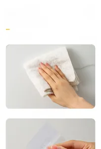 Close-up of wall-mounted mop holder installation process on grey marble tiles