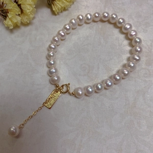 Macro shot of Baroque pearls bracelet with gold clasp and Hand Made tag detail