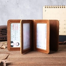 Macro detail of a brown leather wallet showing white stitching and multiple card slots