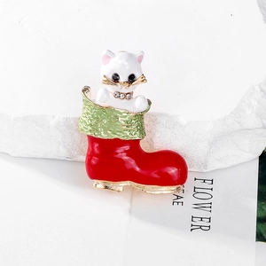 Close-up of a Christmas cat brooch in a red stocking with enamel details and sparkles