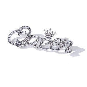 Gros plan sur la broche Queen argentée avec détail couronne et strass brillants