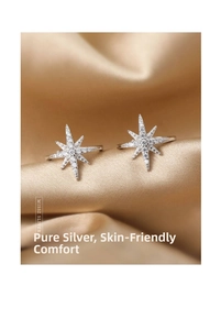 Macro shot of silver star-shaped ear clips in sterling silver with sparkling zircons