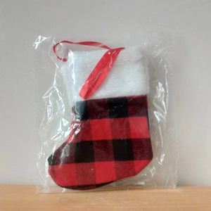Detail of red and black buffalo plaid Christmas stocking with white faux fur cuff in package