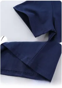 Detail of dark blue cotton kids T-shirt showing double-needle stitching on cuff and hemline
