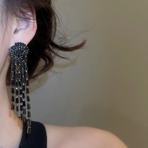 Gros plan de boucles d'oreilles élégantes à pampilles en strass noirs sur un modèle