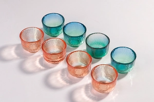 Set of eight Japanese style hammered glass cups in gradient orange and blue green hues