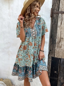 Detail of V-neck button closure and floral print on a green Bohemian summer dress