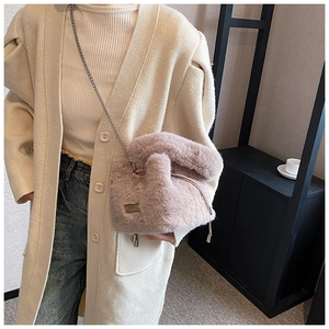 Close-up of pink faux fur bucket bag with metal chain strap and drawstring closure