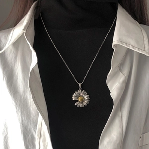 Daisy pendant necklace with silver beaded chain shown on model with layered clothing
