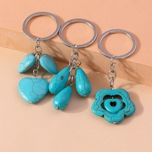Detail of silver keychains with turquoise leaf, water drop, and floral heart pendants