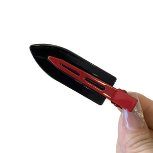 Glossy red and black oil painting style hair clip with metal grip held by hand