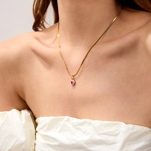 Dettaglio collana a serpente 18k con cuore in smalto rosa e pendente in zircone rosso